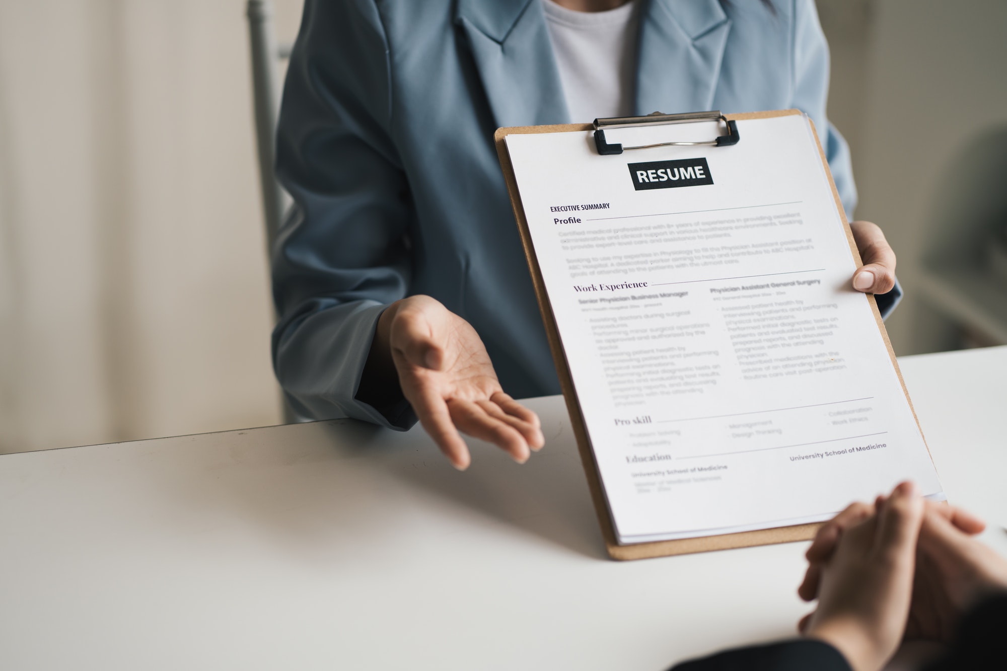 Woman submits job application, Interviewer reading a resume.